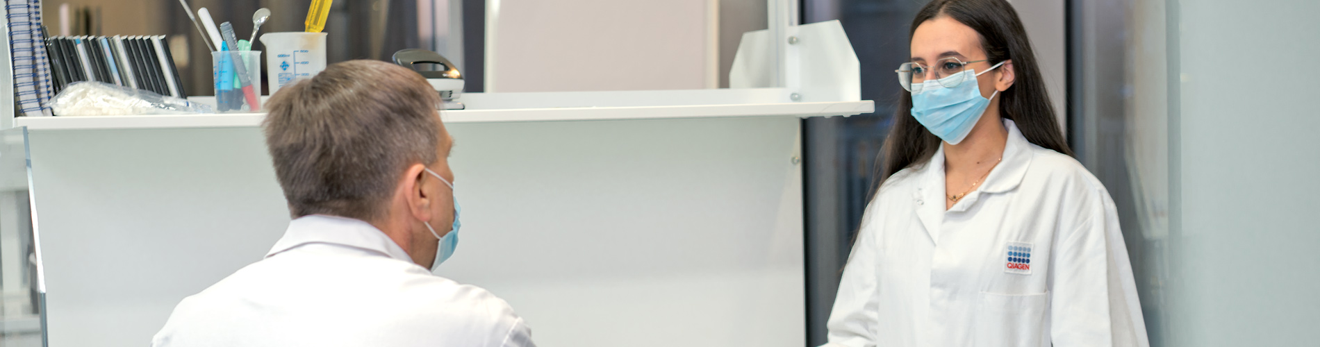 Two scientist discussing, document zone in a lab, laboratory, iPad, mobile device, mask, wearing masks, labcoat